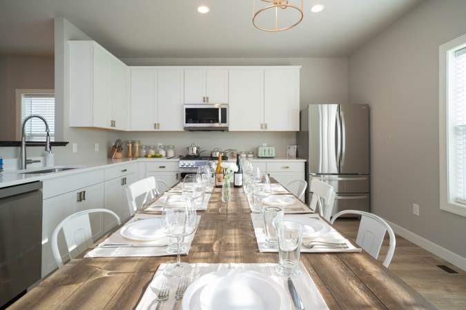 Kitchen with white cabinets and a long dining table