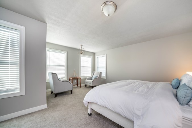Primary bedroom with a sitting area by the windows