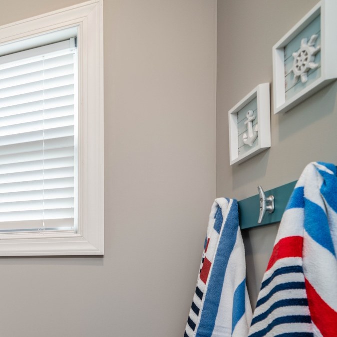 Bathroom with beach towels hanging on boat-cleat hooks