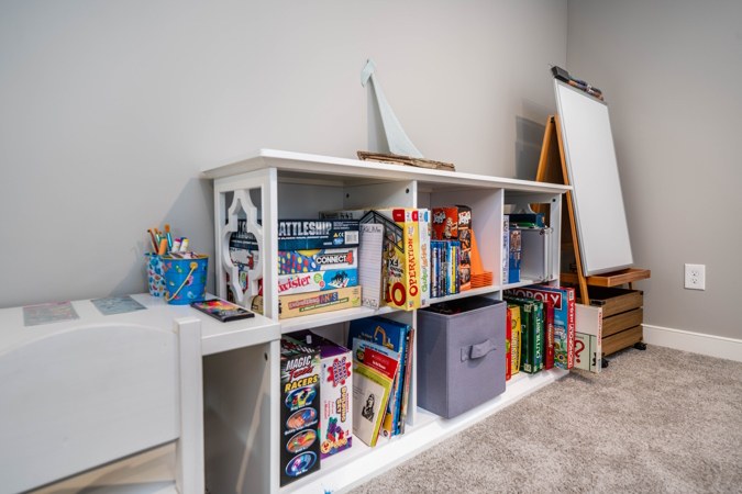 Shelves of board games and books, with an easel