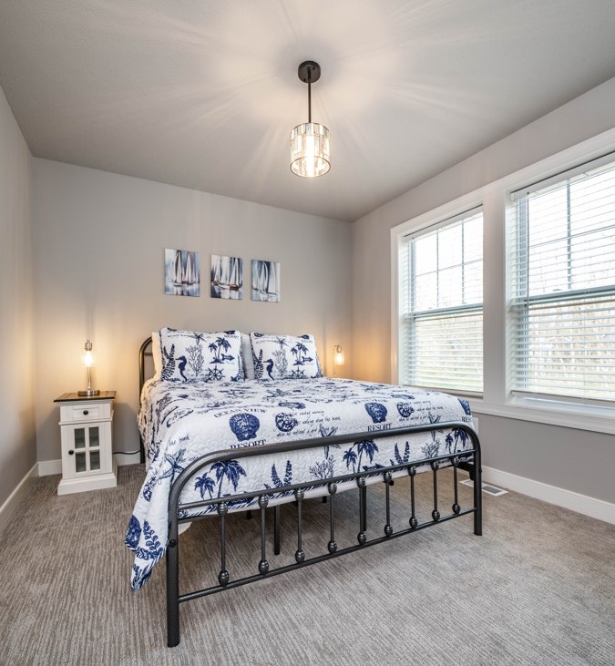 Bedroom with an iron bed and blue-and-white bedding