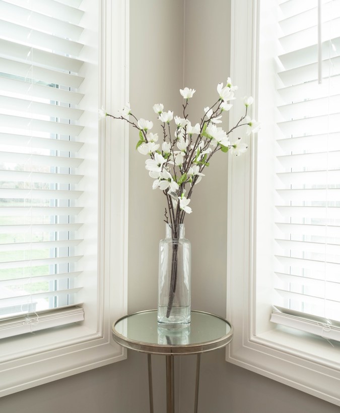 Window corner with a vase of white flowers