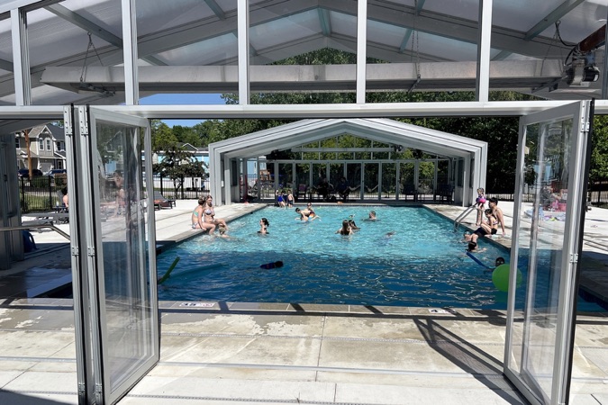 Swimmers in the community pool with the glass walls open
